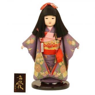 日本を代表する人形として、昔から愛されている市松人形。市松人形の名前の由来は江戸時代の人気歌舞伎役者から来ていると言われています。
こちらは上品な紫の正絹衣装に古典的な菊の柄をあしらった上品な市松人形です。制作は市松人形制作で有名な齊藤公司作です。