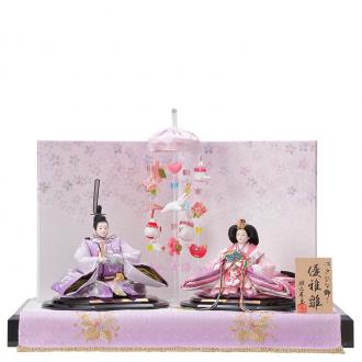 人形の衣裳は紫〜ピンク暈しの生地にお揃いの「雪輪に桜」柄の刺繍付きです。中央には「吊るし飾り」をセッティングしました。