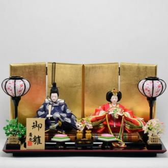 京都西陣金襴裂地の伝統的な有職文様のお衣装のお雛様。飾台は、漆器の産地で有名な富山県の高岡塗。屏風は、手貼り金箔押し仕上げです。