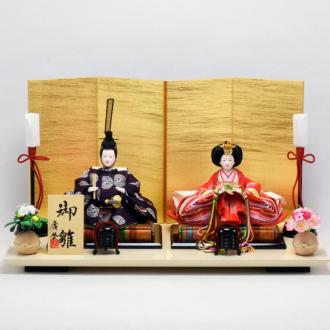 京都西陣金襴裂地の伝統的な有職文様のお衣装のお雛様。飾台は、漆器の産地で有名な富山県の高岡塗。バニラホワイト色と金屏風の組み合わせが、モダンな雛人形で華やかなお節句を演出します。